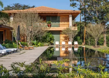 Casa a beira de lago na Quinta da Baroneza integra novos volumes à paisagem do campo