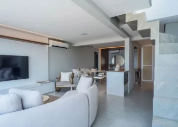 Nesse outono, já estamos vivenciando dias que, ao cair da tarde, o ventinho vem dar o ar da graça. Sofás e poltronas se tornam ainda mais acolhedores com a adição de mantinhas que aquecem os moradores enquanto aproveitam a sala de estar | Projeto Meneghisso & Pasquotto Arquitetura | Livia Krass
