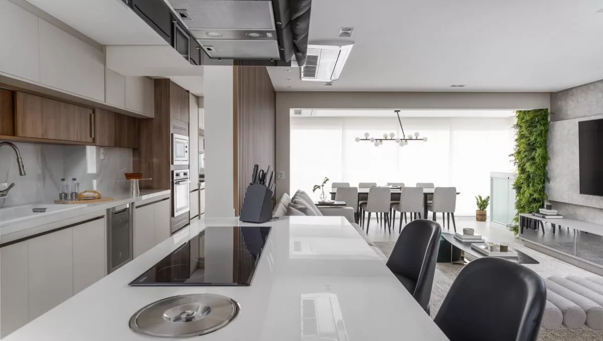 Nos projetos residenciais, a cozinha integrada deixou de ser um dilema, assim como nesse projeto realizado pelas arquitetas Fabiana Villegas e Gabriela Vilarrubia. Por aqui, a cozinha corredor ganhou uma península com múltiplas funções: além de receber o cooktop de indução, tornou-se bancada para refeições rápidas e uma área de interação quando os moradores recebem convidados | Projeto: Vilaville Arquitetura | Foto: JP Image
