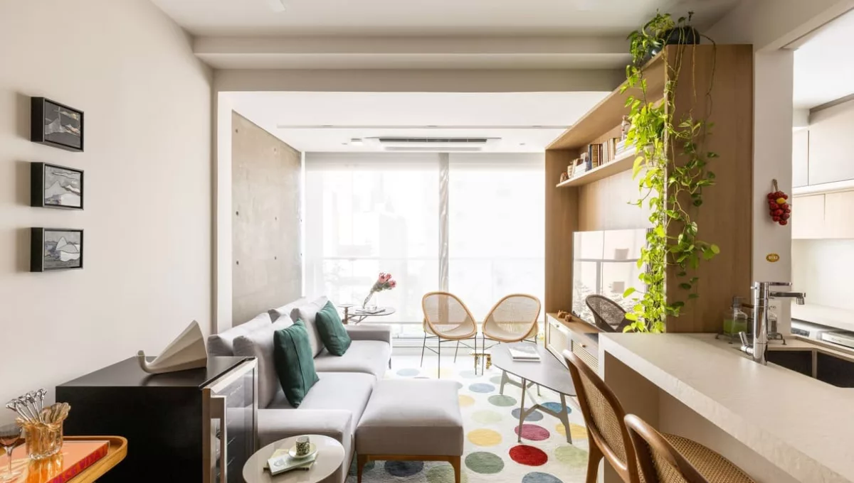 Neste living assinado pela arquiteta Elisa Maretti, o tapete de cores vibrantes assume o protagonismo. Com formato circular, ele contrasta com as linhas retas do ambiente, adicionando leveza, movimento e um toque de descontração ao espaço | Foto: Manuel Sá