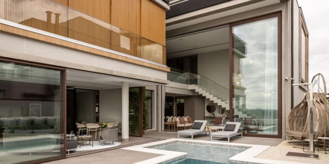 O projeto contemplou a criação de três suítes, área íntima, living, sala de cinema, cozinha e área gourmet totalmente equipadas, além de uma grande piscina com borda infinita e hidromassagem | Projeto: Meneghisso & Pasquotto Arquitetura | Foto: JP Image