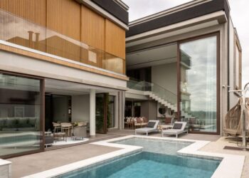 O projeto contemplou a criação de três suítes, área íntima, living, sala de cinema, cozinha e área gourmet totalmente equipadas, além de uma grande piscina com borda infinita e hidromassagem | Projeto: Meneghisso & Pasquotto Arquitetura | Foto: JP Image