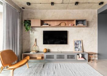 Nesta sala de estar executada pelo arquiteto Bruno Moraes, os tons de cinza definem seu charme ao unir concreto aparente, tecidos macios, detalhes metálicos, marcenaria imponente e o porcelanato do piso, todos dentro da mesma família cromática | Projeto BMA Studio | Foto: Guilherme Pucci